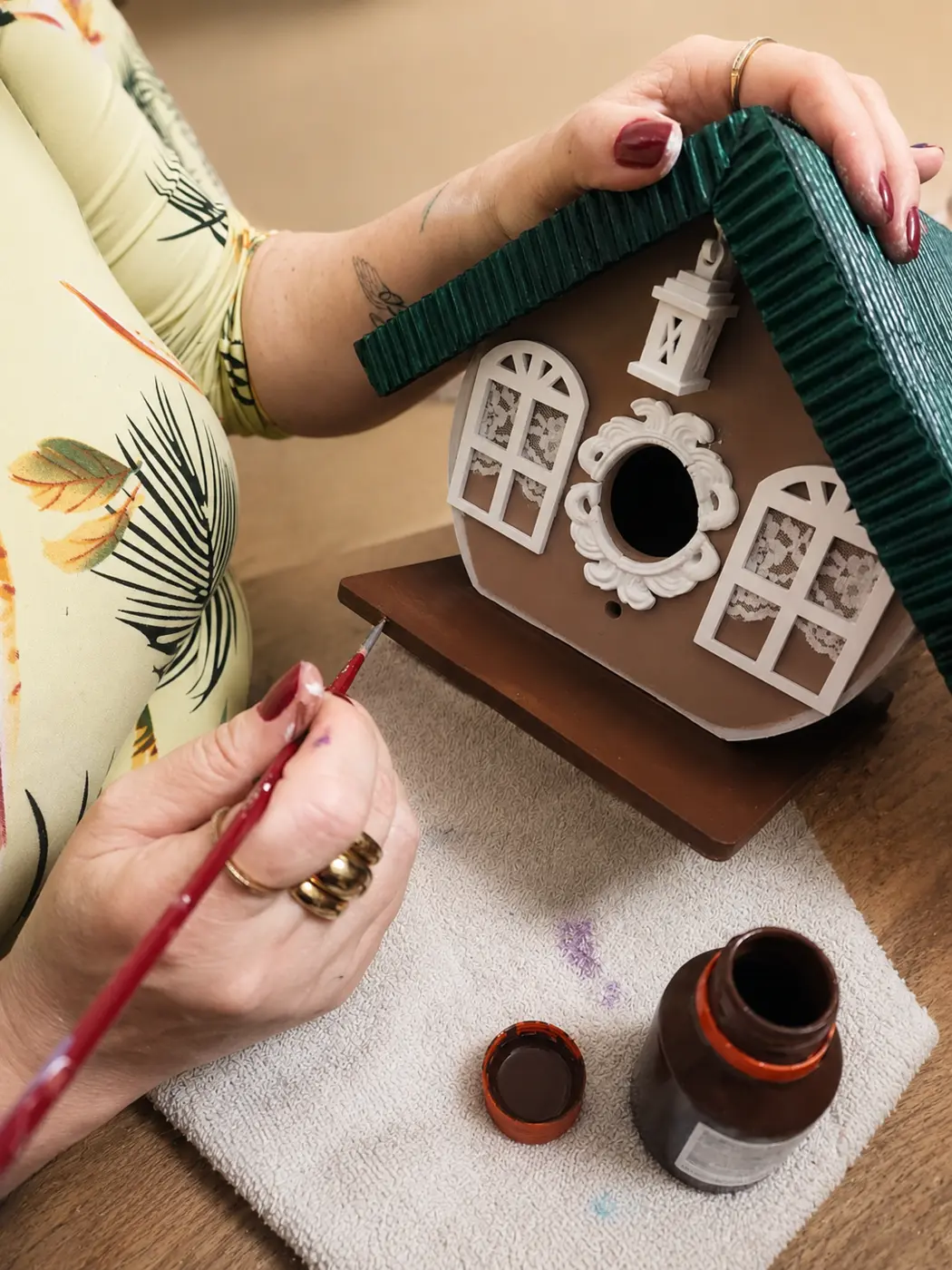 Julici pintando uma casinha artesanal
